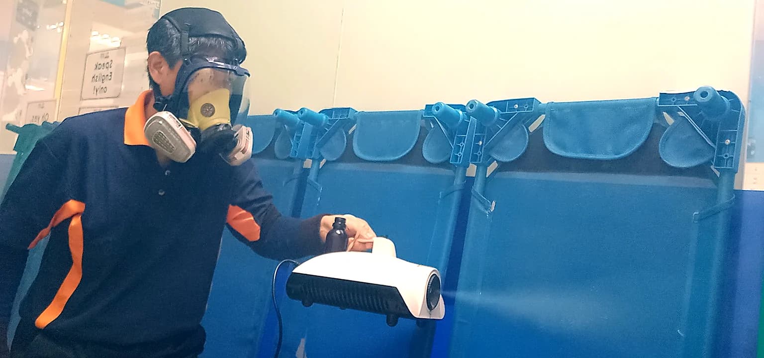 JA Hygiene technician carrying out service beside classroom seating